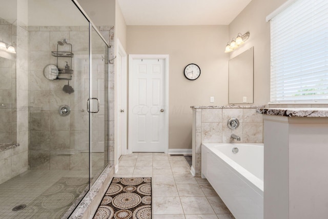 bathroom featuring a stall shower, a garden tub, tile patterned flooring, and baseboards