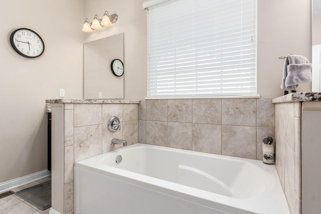 bathroom featuring healthy amount of natural light, a bath, vanity, and baseboards