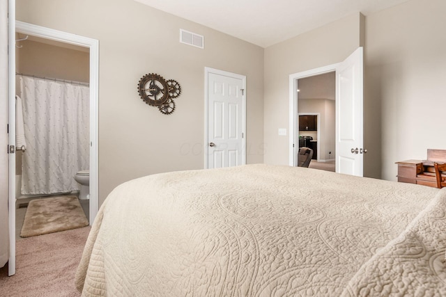 bedroom with carpet floors and ensuite bathroom