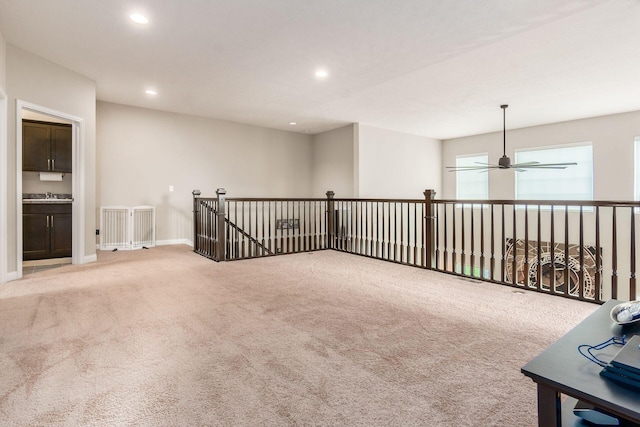carpeted spare room with ceiling fan, recessed lighting, baseboards, and a sink