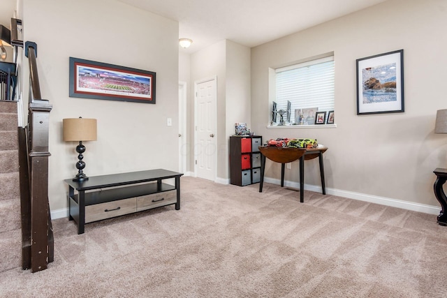 living area featuring carpet flooring, stairway, and baseboards