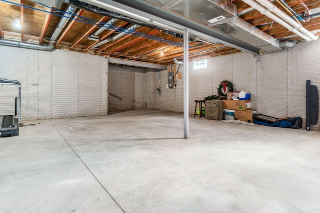 basement with electric panel and brick wall