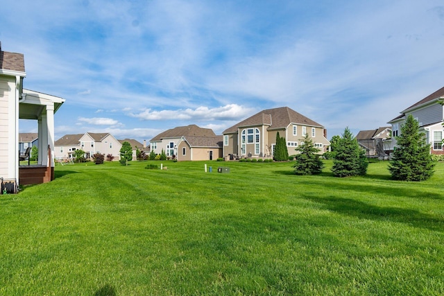 view of grassy yard featuring a residential view