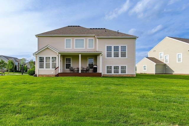 back of house with a yard, a patio, and a shingled roof