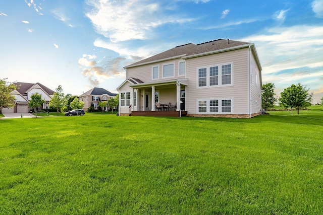 rear view of property featuring a lawn