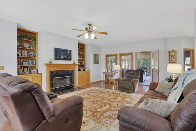 80 Baltimore Somerset Rd NW, Baltimore, OH 43105 - living room with ceiling fan, wood finished floors, built in shelves, a tiled fireplace, and baseboards