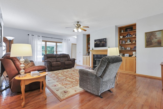 80 Baltimore Somerset Rd NW, Baltimore, OH 43105 - living room featuring a fireplace, light wood-style floors, built in features, and ceiling fan