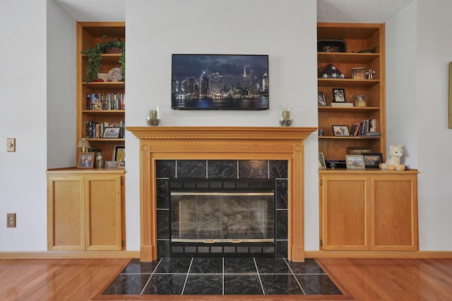 80 Baltimore Somerset Rd NW, Baltimore, OH 43105 - living room featuring a tiled fireplace, wood finished floors, built in features, and a textured ceiling