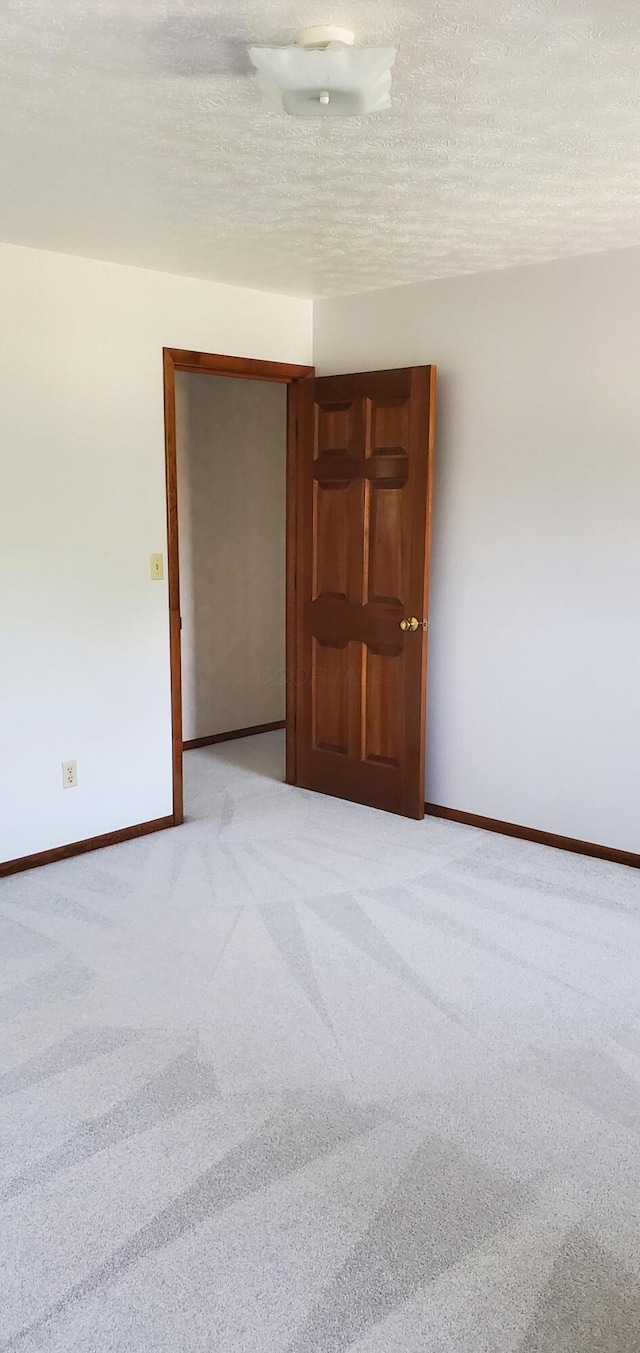 4993 Shadycrest Rd, Columbus, OH 43229 - spare room with light colored carpet, baseboards, and a textured ceiling