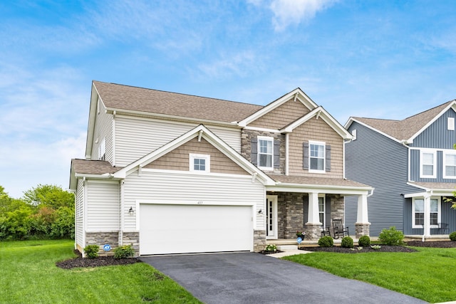 417 Oakland Hills Loop, Commercial Point, OH 43116 - craftsman-style home featuring stone siding, a porch, asphalt driveway, and a front lawn