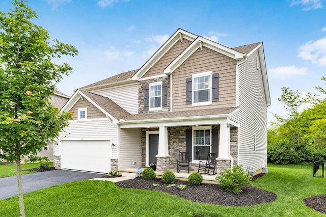 417 Oakland Hills Loop, Commercial Point, OH 43116 - craftsman-style home featuring a porch, stone siding, driveway, a front yard, and a shingled roof