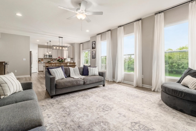 417 Oakland Hills Loop, Commercial Point, OH 43116 - living room with light wood-style flooring, a ceiling fan, baseboards, recessed lighting, and a chandelier