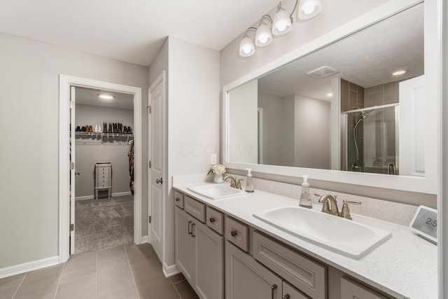 417 Oakland Hills Loop, Commercial Point, OH 43116 - full bathroom featuring a shower stall, tile patterned floors, double vanity, baseboards, and a spacious closet