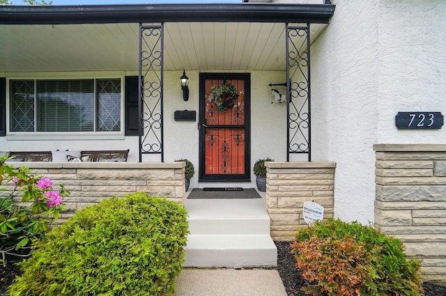 723 W Winmar Pl, Westerville, OH 43081 - doorway to property featuring covered porch, stucco siding, and stone siding
