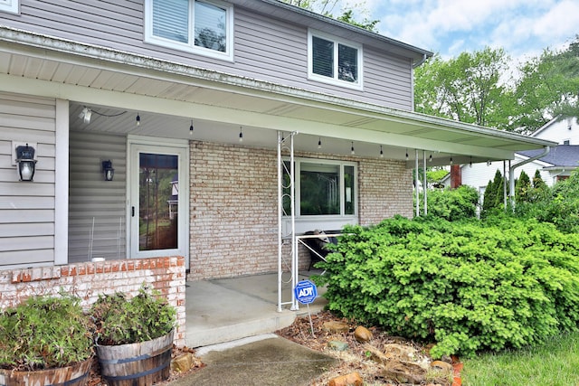 327 Warlock Ct, Columbus, OH 43230 - doorway to property with brick siding and a porch