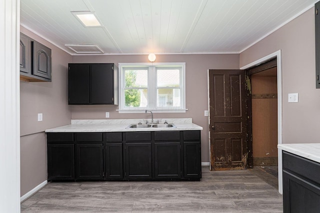 167 Essex St, Newark, OH 43055 - kitchen featuring a sink, light countertops, light wood-style flooring, dark cabinets, and crown molding