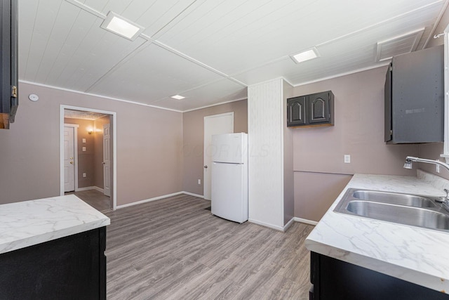 167 Essex St, Newark, OH 43055 - kitchen with freestanding refrigerator, a sink, light countertops, light wood-style flooring, and baseboards
