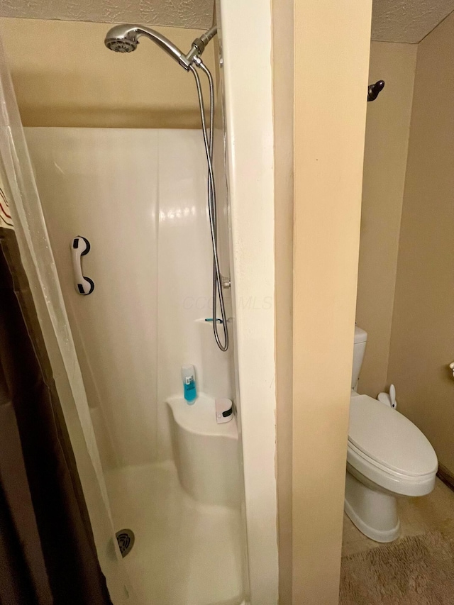 346 Instone Dr, Reynoldsburg, OH 43068 - bathroom featuring a shower stall, toilet, and a textured ceiling