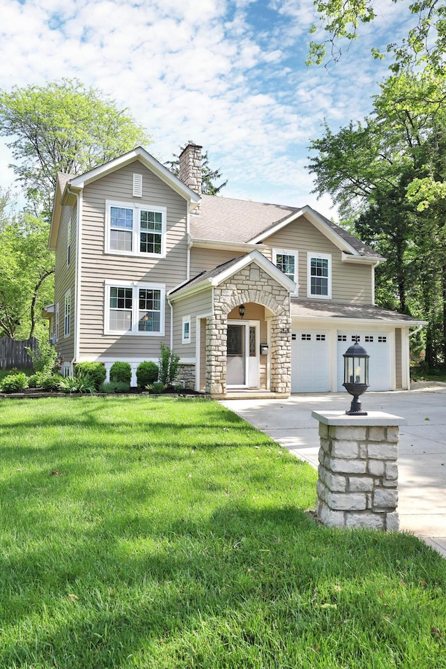 258 Canyon Dr, Columbus, OH 43214 - view of front of house featuring concrete driveway, a chimney, a garage, a front yard, and stone siding