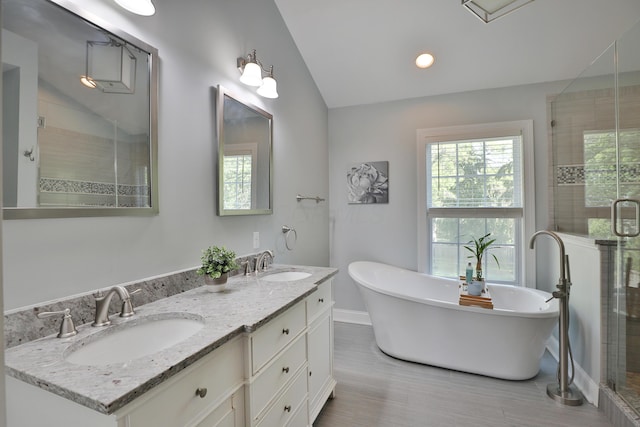 258 Canyon Dr, Columbus, OH 43214 - full bath featuring lofted ceiling, a shower stall, baseboards, double vanity, and a soaking tub