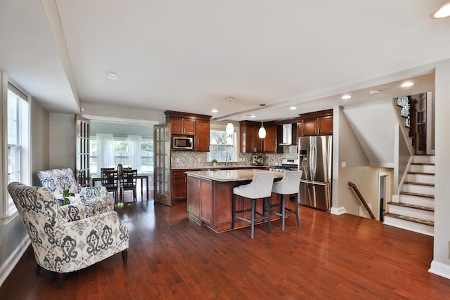 258 Canyon Dr, Columbus, OH 43214 - kitchen with appliances with stainless steel finishes, a center island, dark wood finished floors, tasteful backsplash, and recessed lighting