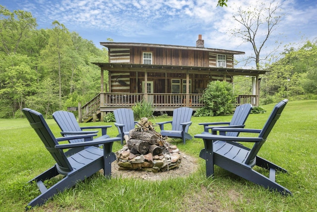 23587 Woltz Rd, Rockbridge, OH 43149 - rear view of house with a fire pit, a chimney, a yard, and a deck