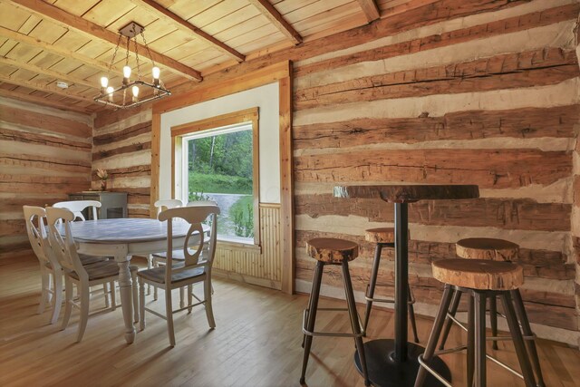 23587 Woltz Rd, Rockbridge, OH 43149 - dining area with wood walls, wood ceiling with exposed beams, a chandelier, and light wood-style floors