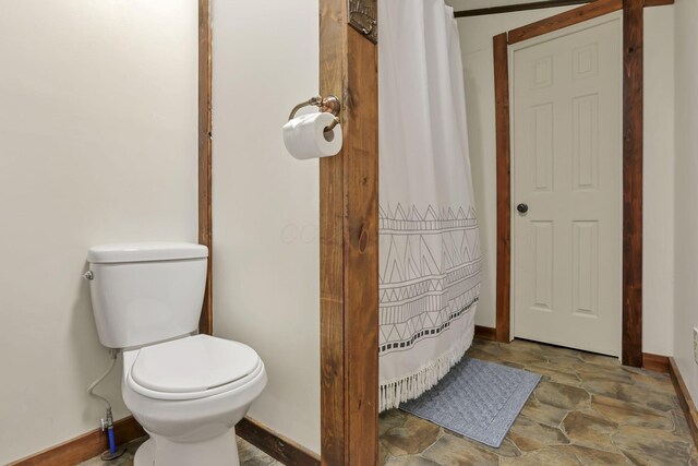 23587 Woltz Rd, Rockbridge, OH 43149 - bathroom with baseboards, toilet, stone finish flooring, and a shower with curtain