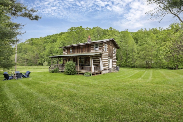 23587 Woltz Rd, Rockbridge, OH 43149 - back of property with a wooded view, a yard, a chimney, and central air condition unit