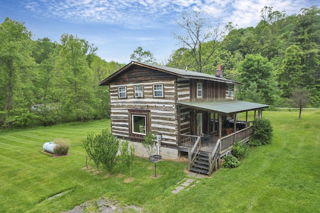 23587 Woltz Rd, Rockbridge, OH 43149 - view of front of home with a front lawn, a chimney, a wooded view, and covered porch