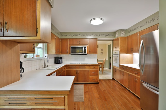 6653 Merwin Rd, Columbus, OH 43235 - kitchen with appliances with stainless steel finishes, a sink, light wood-type flooring, light countertops, and backsplash
