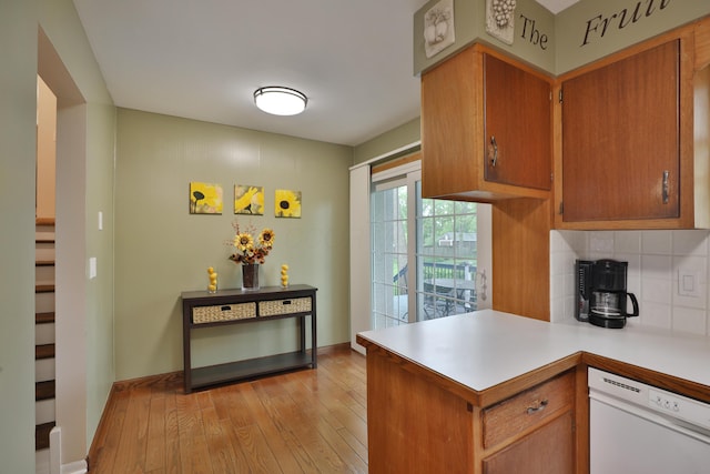 6653 Merwin Rd, Columbus, OH 43235 - kitchen featuring white dishwasher, light wood-type flooring, light countertops, tasteful backsplash, and a peninsula