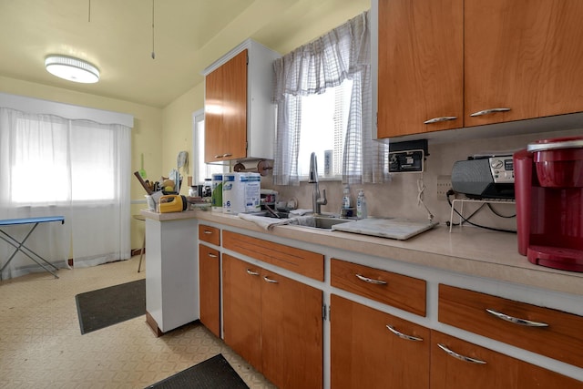 1920 S Champion Ave, Columbus, OH 43207 - kitchen featuring light countertops, brown cabinets, a sink, and light flooring