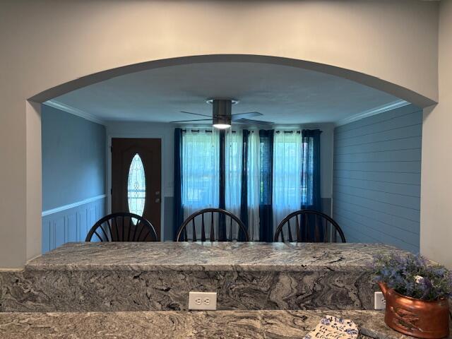 4367 Helena Ct, Springfield, OH 45503 - dining room with arched walkways, a ceiling fan, crown molding, and a wainscoted wall