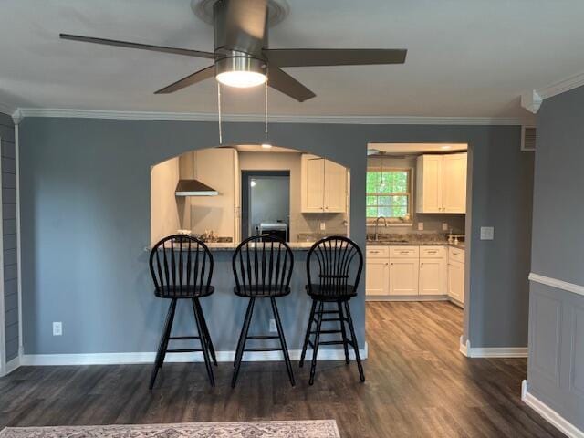 4367 Helena Ct, Springfield, OH 45503 - kitchen with ceiling fan, a kitchen bar, ornamental molding, dark wood-style floors, and white cabinets