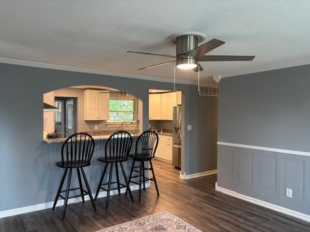 4367 Helena Ct, Springfield, OH 45503 - kitchen featuring stainless steel refrigerator with ice dispenser, ceiling fan, a kitchen bar, dark wood-style flooring, and arched walkways