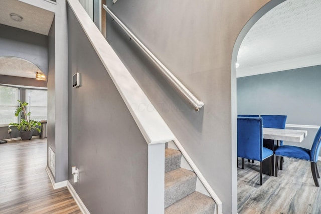 1536 Mulligan Ct, Reynoldsburg, OH 43068 - staircase featuring arched walkways, wood finished floors, baseboards, crown molding, and a textured ceiling