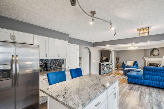 1536 Mulligan Ct, Reynoldsburg, OH 43068 - kitchen featuring stainless steel fridge with ice dispenser, light wood-type flooring, white cabinets, and a textured ceiling
