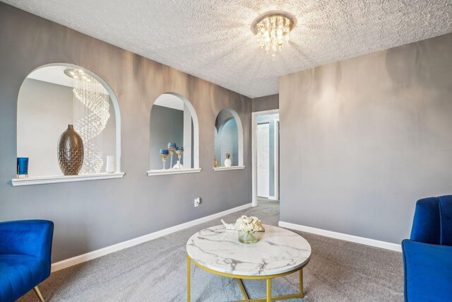 1536 Mulligan Ct, Reynoldsburg, OH 43068 - living area featuring a chandelier, carpet floors, a textured ceiling, and baseboards