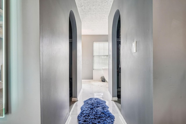 1536 Mulligan Ct, Reynoldsburg, OH 43068 - hall featuring arched walkways, a textured ceiling, and baseboards