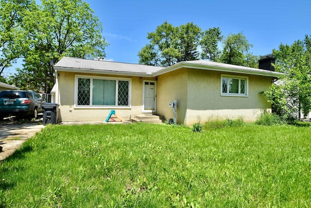 4510 Broadhurst Dr, Columbus, OH 43213 - view of front of property with stucco siding, a front lawn, a chimney, and metal roof