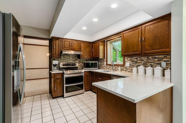 665 Northbridge Ct, Westerville, OH 43081 - kitchen with stainless steel appliances, a sink, under cabinet range hood, a peninsula, and light tile patterned flooring