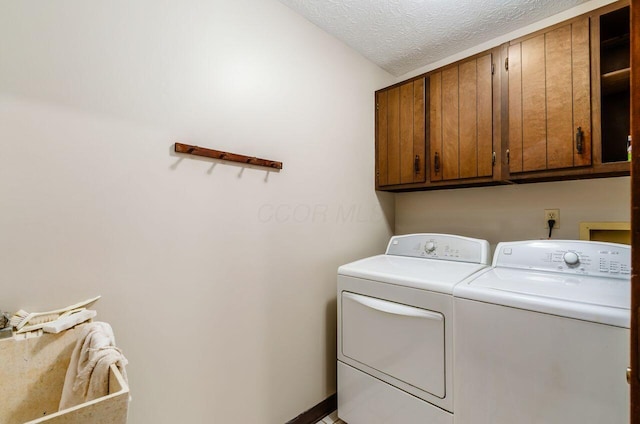 665 Northbridge Ct, Westerville, OH 43081 - laundry area featuring cabinet space, washing machine and dryer, and a textured ceiling