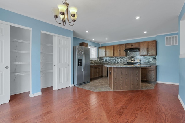 7429 Willow Leaf Dr, Canal Winchester, OH 43110 - kitchen featuring stainless steel appliances, under cabinet range hood, dark wood-style flooring, a chandelier, and decorative backsplash