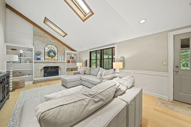 1009 Tall Tree Ct, Westerville, OH 43081 - living area featuring a skylight, lofted ceiling, plenty of natural light, light wood-style flooring, and a fireplace