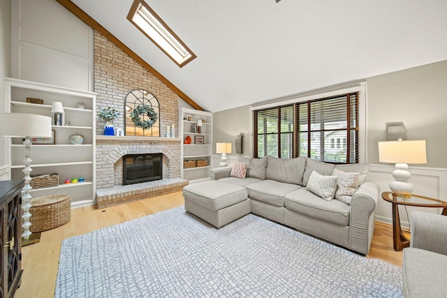 1009 Tall Tree Ct, Westerville, OH 43081 - living area with vaulted ceiling, a fireplace, wood finished floors, built in shelves, and a skylight