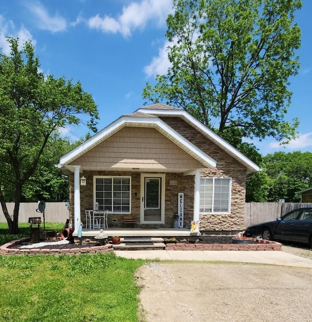 view of front of home with covered porch and stone siding