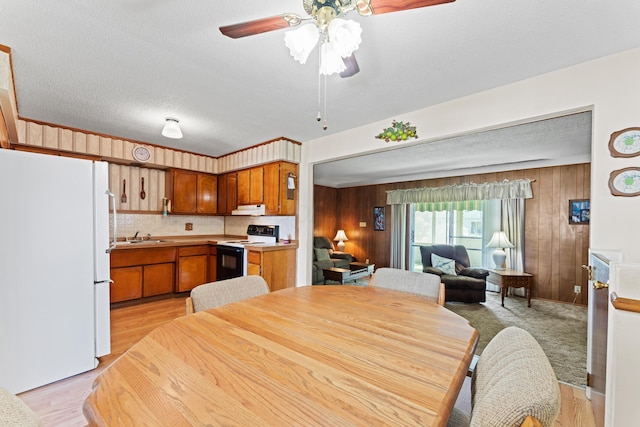 4818 Manitoba Rd, Columbus, OH 43229 - dining room with wooden walls, ceiling fan, light wood-type flooring, and a textured ceiling