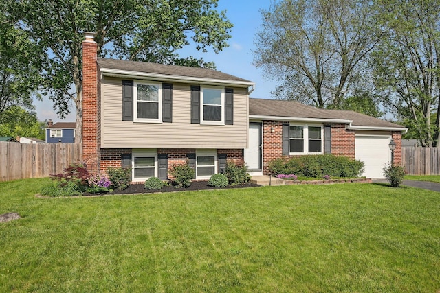 651 Dovalon Pl, Galloway, OH 43119 - tri-level home with a chimney, an attached garage, brick siding, and driveway