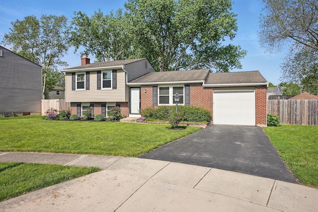 651 Dovalon Pl, Galloway, OH 43119 - tri-level home featuring brick siding, an attached garage, driveway, and a chimney